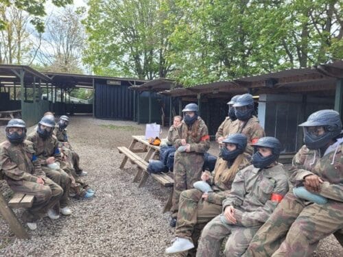 A vibrant sunset over a serene landscape, featuring rolling hills and trees silhouetted against the colorful sky.